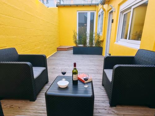 a bottle of wine sitting on a table on a patio at - Apparts nets à prix honnête - in Brest