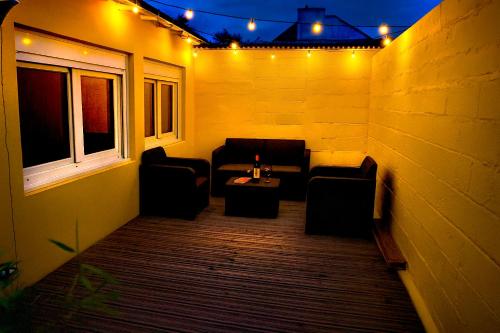 a patio with couches and a table and lights at - Apparts nets à prix honnête - in Brest