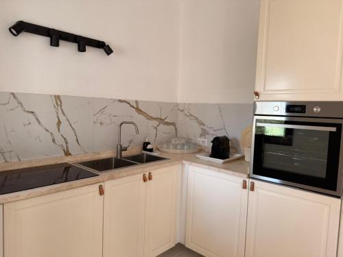 a kitchen with a sink and a microwave at CasaNica - Elegant independent apartment in Torpè