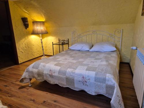 a bedroom with a bed with a quilt and a lamp at Bocianówka in Baranów Sandomierski