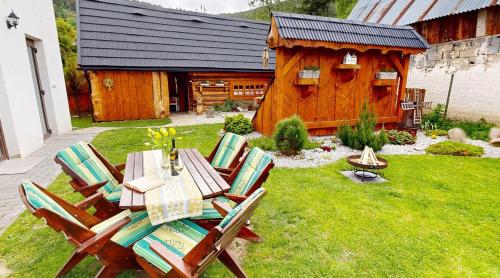 a table and chairs in a yard with a log cabin at Oravienka in Oravský Biely Potok