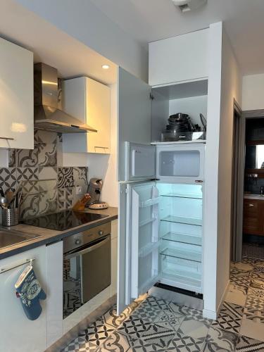 a kitchen with white cabinets and an open pantry at Appartement au cœur de bandol avec parking plage à 1 mn ! in Bandol