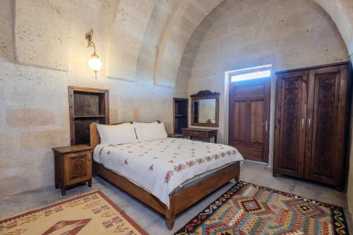 a bedroom with a bed and a mirror and a door at Chardonnay Suites Hotel in Avanos