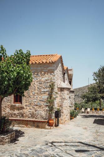 a stone building with a tree in front of it at Krassopsychia Apartments in Krásion