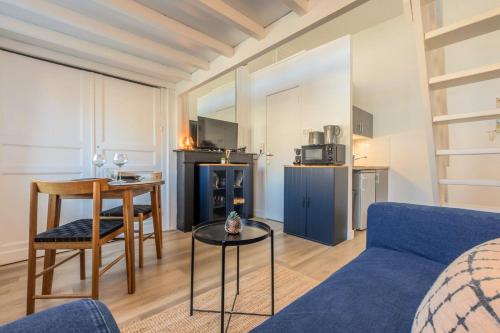 un salon avec un canapé bleu et une table dans l'établissement Joli studio à deux pas de l'Université Catholique, à Lille
