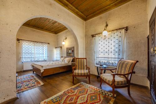 a bedroom with a bed and a table and chairs at Chardonnay Suites Hotel in Avanos