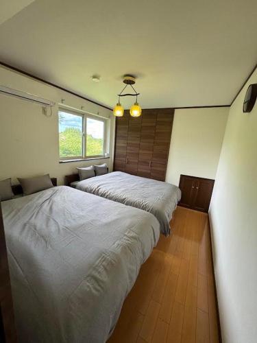 a bedroom with two beds and a window at 那須青木 Fabulous House 一棟貸 BBQ in Nasushiobara