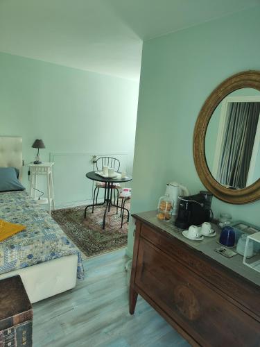 a bedroom with a bed and a mirror on a dresser at La Casa della Rosa Nana in Trezzano sul Naviglio