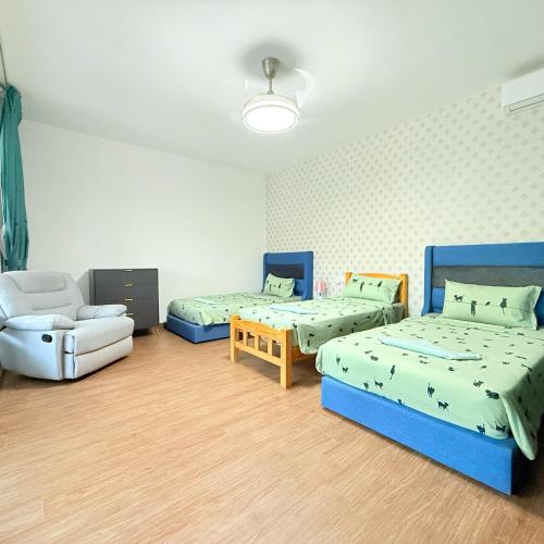 Habitación con 3 camas, silla y sofá en Villa in Forest City Golf Club J2-57, en Johor Bahru