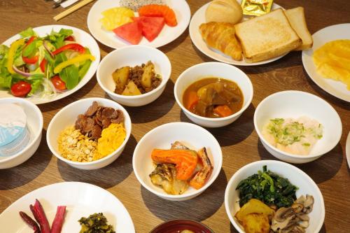 a table topped with white bowls filled with different types of food at Sotetsu Grand Fresa Bangkok in Bangkok