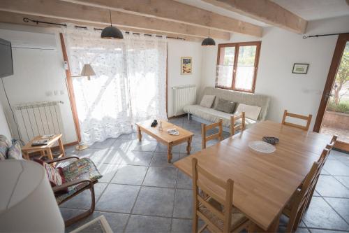 a living room with a table and a couch at Gites au Cœur de la Nature, Piscine et Vue sur le Lac du Salagou in Le Puech
