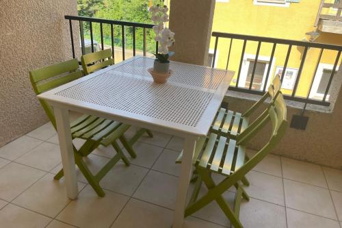 une table blanche avec deux chaises et un vase avec des fleurs dans l'établissement F24 Les Naïades- 1 bedroom for 4 people !, à Avène