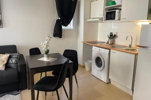 une petite cuisine avec une table et un lave-linge. dans l'établissement F24 Les Naïades- 1 bedroom for 4 people !, à Avène