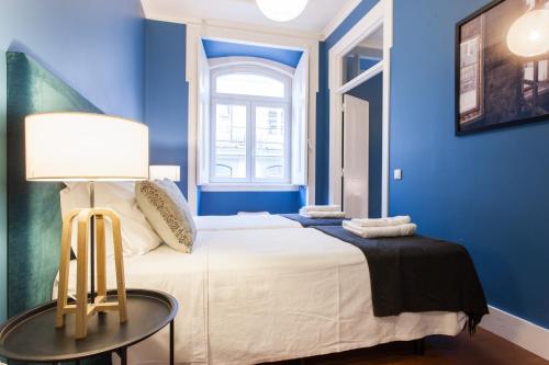 A bed or beds in a room at FLH Baixa Blue Apartment