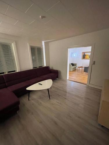 a living room with a couch and a table at Villa - private parking in Holsted