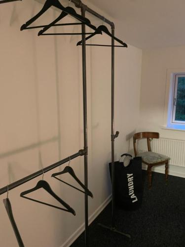 a closet with hangers and a chair in a room at Villa - private parking in Holsted