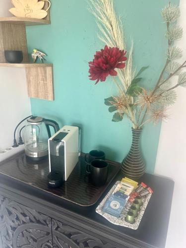 une table avec une radio et un vase avec des fleurs dans l'établissement Chambre indépendante avec jacuzi et climatisation, à Vanzy