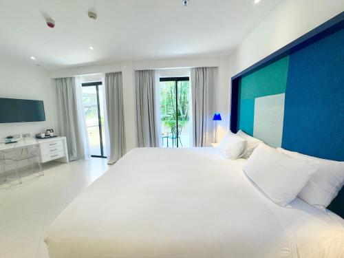 a large bedroom with a large bed with a blue headboard at Hilton Sorrento Palace in Sorrento