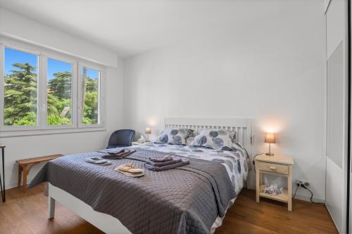 une chambre blanche avec un lit et deux fenêtres dans l'établissement Cannes, Sea View, Beach Access, 3-Bedroom Apartment, 100 m2, 3 Bathrooms, Sleeps 6, 100 meters from Beach, à Cannes