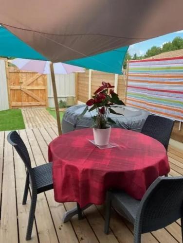 une table avec un tissu de table rouge sur une terrasse dans l'établissement Studio 3 étoiles 20 m2 50 m2 terrasse, à Montalivet-les-Bains