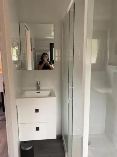 une femme prenant une photo d'un miroir de salle de bains dans l'établissement Studio 3 étoiles 20 m2 50 m2 terrasse, à Montalivet-les-Bains