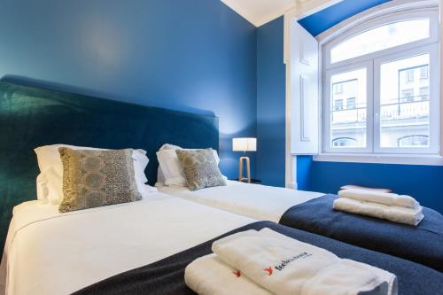 Uma cama ou camas num quarto em FLH Baixa Blue Apartment