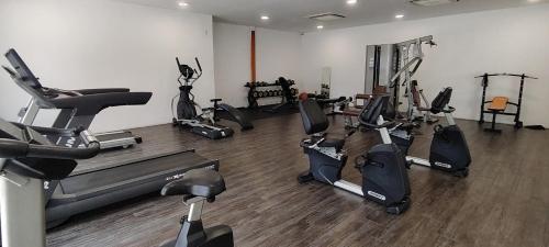 a gym with several tread machines in a room at J&K Guesthouse at Harmoni Apartment, Eco Majestic in Beranang