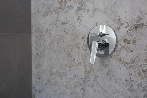 a bathroom with a toilet paper dispenser on a wall at Nonna Francesca 2 in Patti