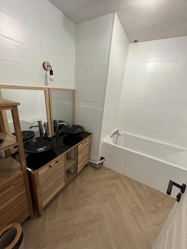 une salle de bain avec deux lavabos et une baignoire dans l'établissement Au Soleil Couchant, à Wimille
