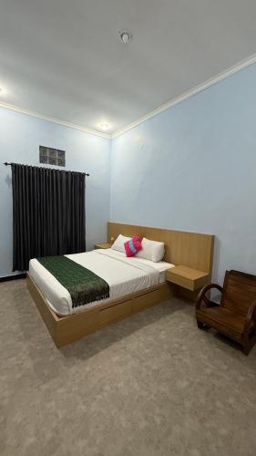 a bedroom with a large bed and a chair at Remedy in Lagas in Ubud