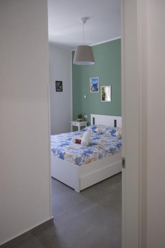 a bedroom with a bed and a green wall at Nonna Francesca 2 in Patti