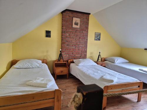 a room with two beds and a brick wall at Bocianówka in Baranów Sandomierski
