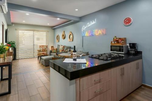 a kitchen with a counter top and a living room at Promo! 2BR-Pool-Views-King Bed-Walk 2 Beach-5 Star Area in Mazatlán