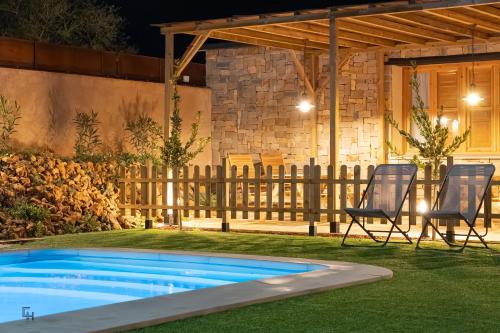 a patio with two chairs and a swimming pool at Casa Hoces - Alma del Cabriel in El Herrumblar