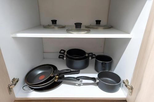 a kitchen with pots and pans on a shelf at Promo! 2BR-Pool-Views-King Bed-Walk 2 Beach-5 Star Area in Mazatlán