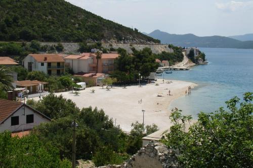 a beach with people on it next to the water at Apartmani Villa Delija Klek in Klek