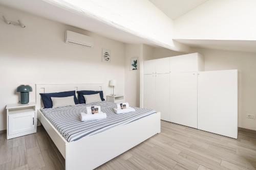 a white bedroom with a large white bed with two pillows at Chianti House, Florence in Florence