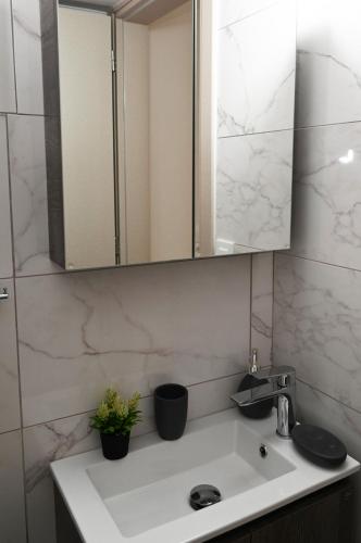 a bathroom with a sink and a mirror at EVDOKIAS Apt,brand new 2025 modern Apt in the center of Alikanas in Alikanas