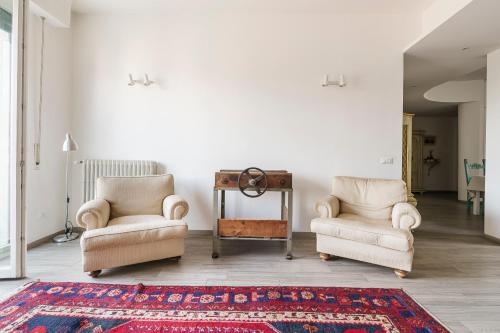 a living room with two chairs and a rug at Chianti House, Florence in Florence
