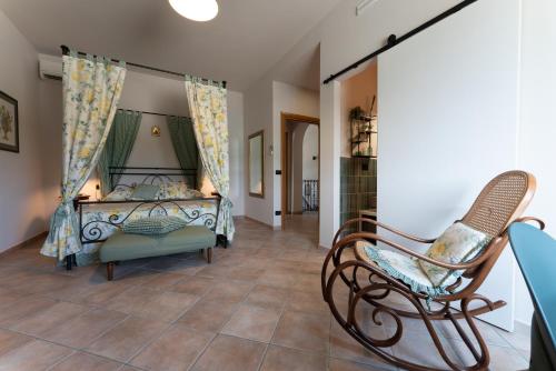 CatignanoにあるTenuta Tre Gemme in Cantina - Suite Tre Gemmeのベッドと椅子のある寝室