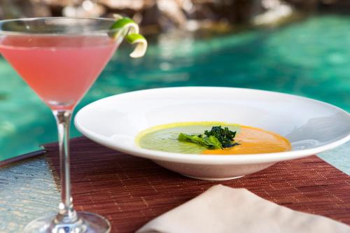 a bowl of soup and a drink on a table at Unwind in Style Villa La Estancia Cabo in Cabo San Lucas