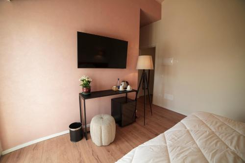 a bedroom with a bed and a tv on the wall at Si Sofia country house 