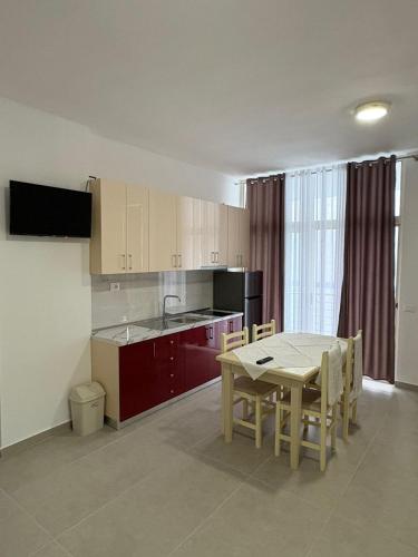 a kitchen with a table and a dining room at Vila Zyle in Velipojë