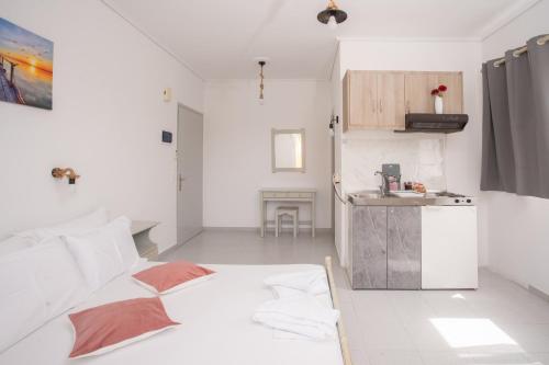 a white room with a bed and a kitchen at AnKo & AnKo 1 in Nydri