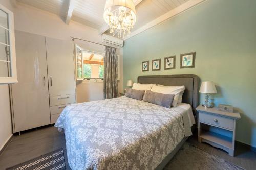 een slaapkamer met een bed en een kroonluchter bij Arilia Country Cottage in Danilia