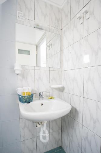 a white bathroom with a sink and a mirror at AnKo & AnKo 1 in Nydri