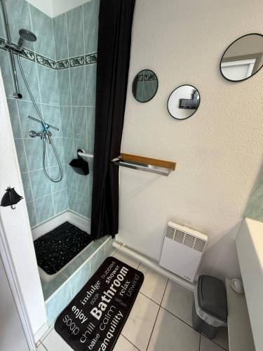 une petite salle de bain avec douche avec un panneau sur le sol dans l'établissement Bleu du Sud, au Cap d'Agde
