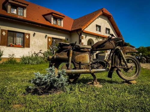 a motorcycle parked in the grass in front of a house at Pensiunea Elena in Criţ