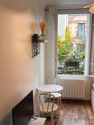 Cette chambre dispose d'une petite table et de chaises. dans l'établissement Bright studio on garden, à Paris