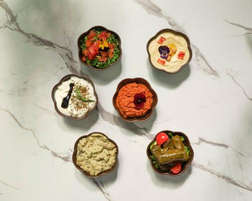 a group of four small bowls of food on a counter at COMO Metropolitan London in London